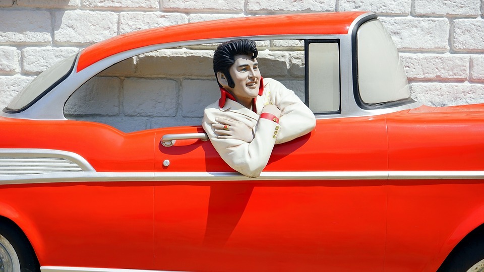 Elvis Presley in a red bel air car