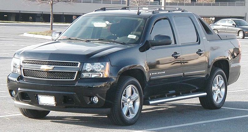 A black Chevy Avalanche parked in a parking lot.