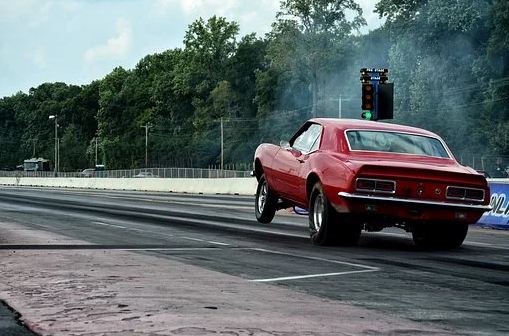 A red muscle car in a drag race