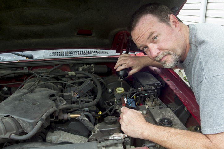 Mechanic Pouring Brake Fluid Into A Master Cylinder