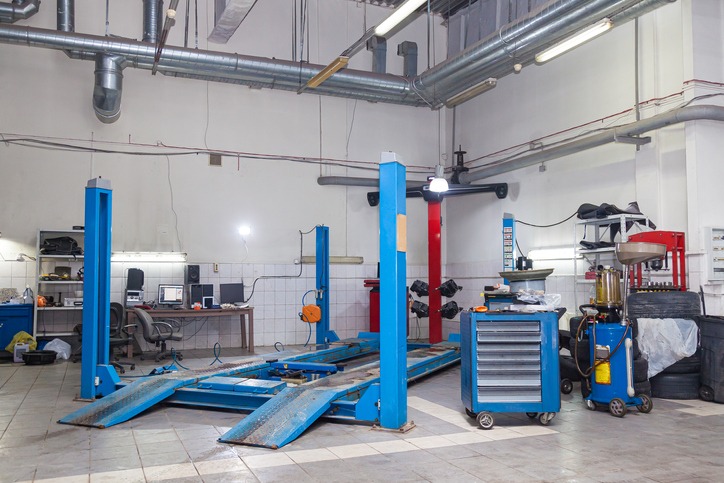 a blue four-post car lift in an auto maintenance shop, auto maintenance tools and equipment
