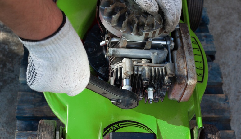 a man repairing a machine using an extension wrench