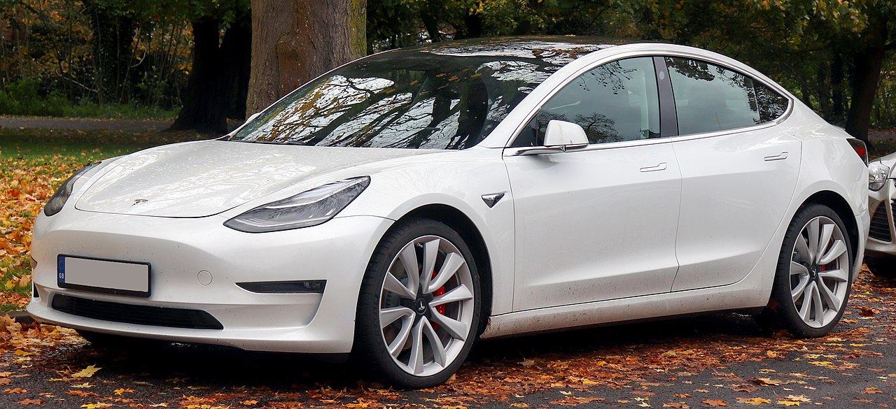  a white Tesla model 3 parked at the side of the road