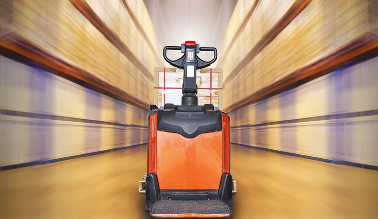 Electric Forklift Pallet Jack in Blurred Warehouse. Shipping Warehouse. Tall Shelf Storage. Supplies Warehouse. Logistics