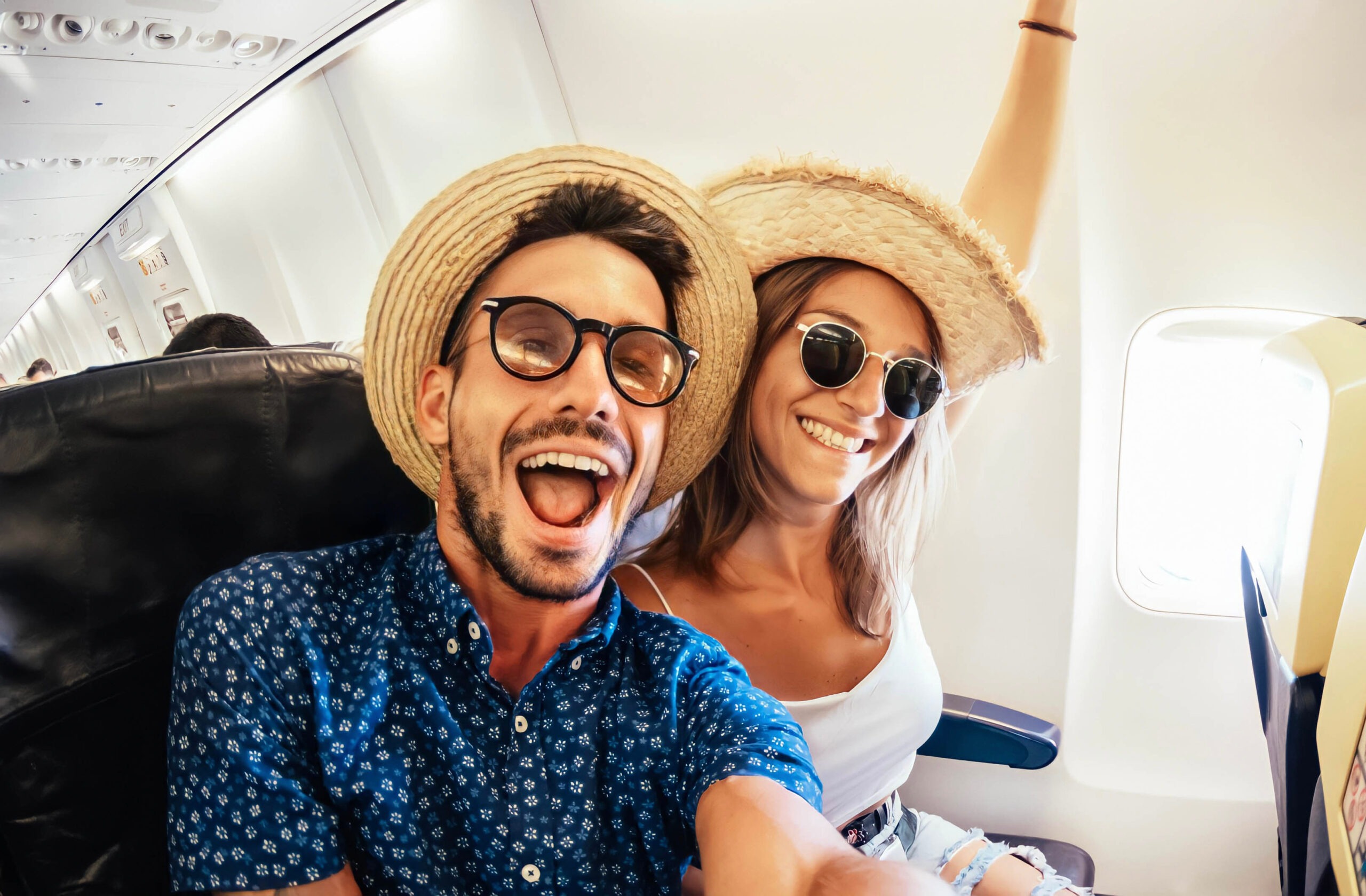 Happy tourist taking selfie inside airplane - Cheerful couple on