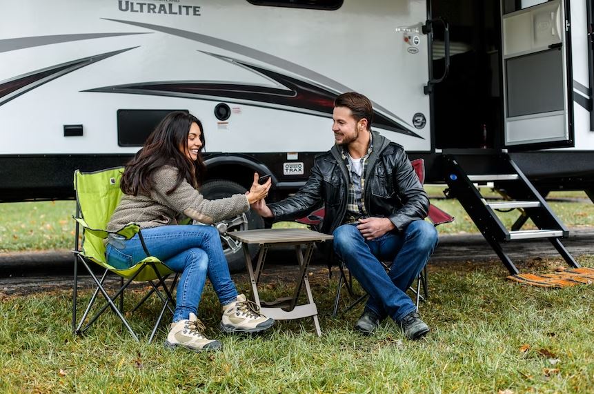 a couple sitting outside a trailer