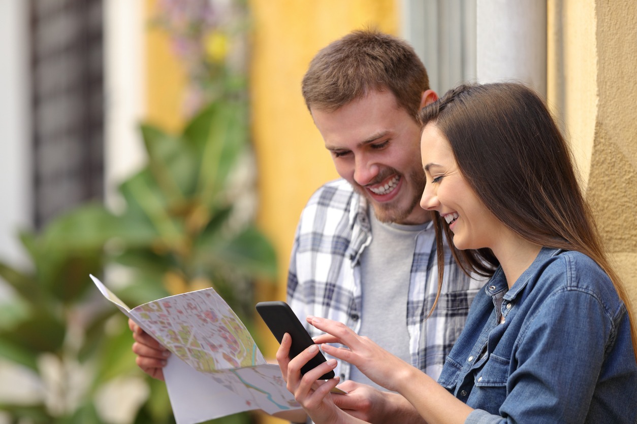 two people looking at a phone and a map