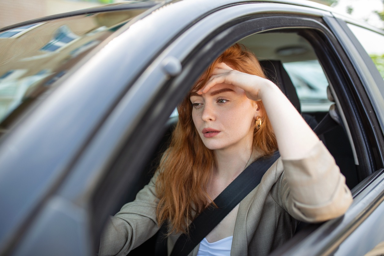 woman feeling stressed while driving her car