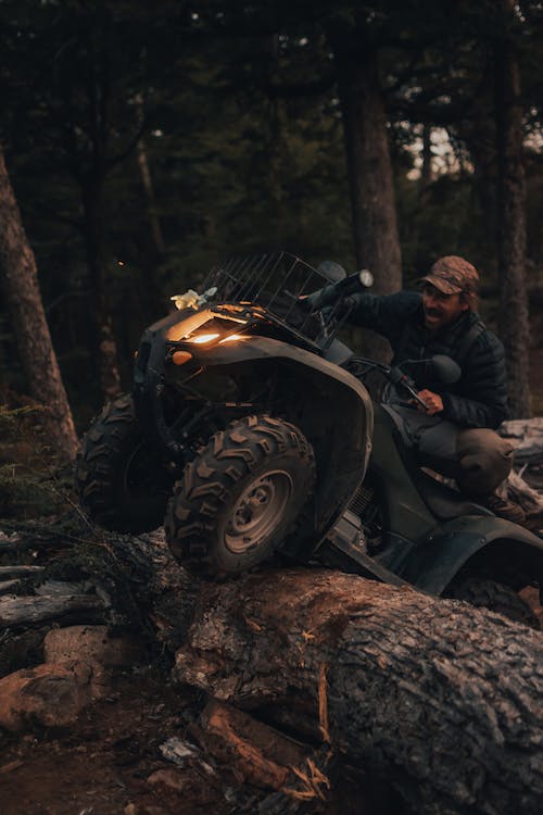 a man riding an all-terrain vehicle in the forest