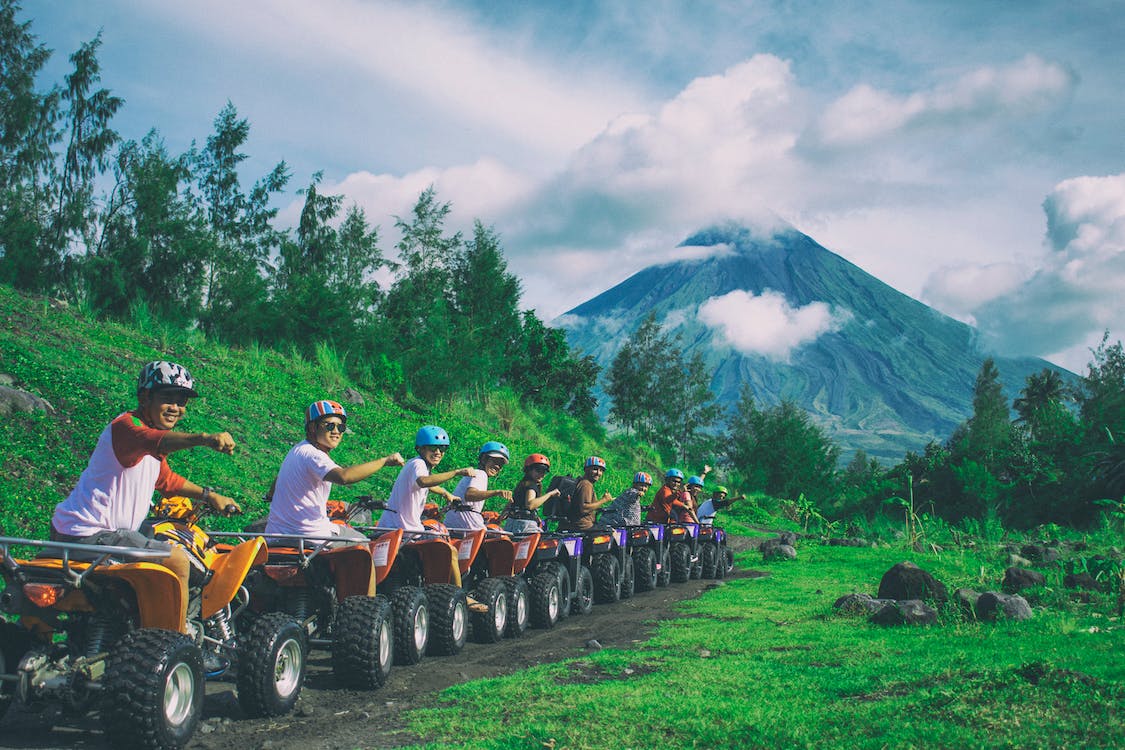 line of men riding on all-terrain vehicles holding out hands in a fist