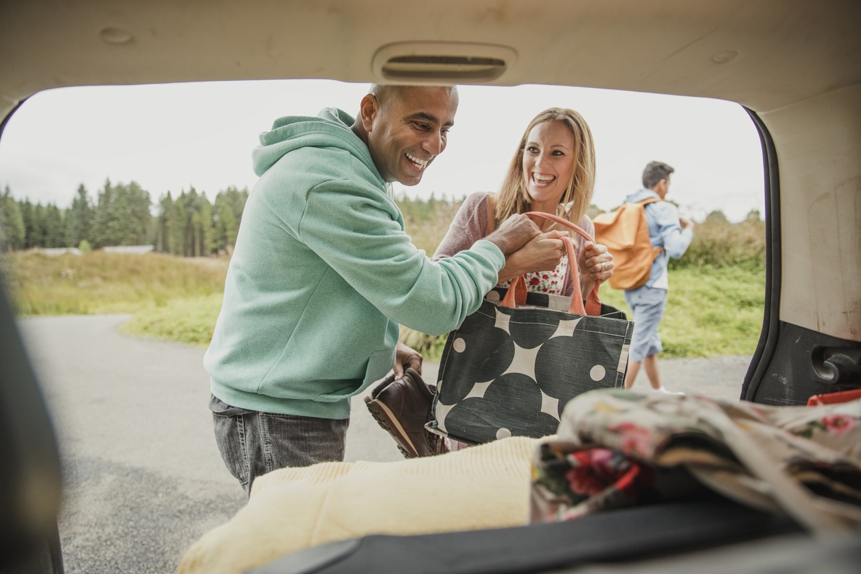 man and woman packing items in the car