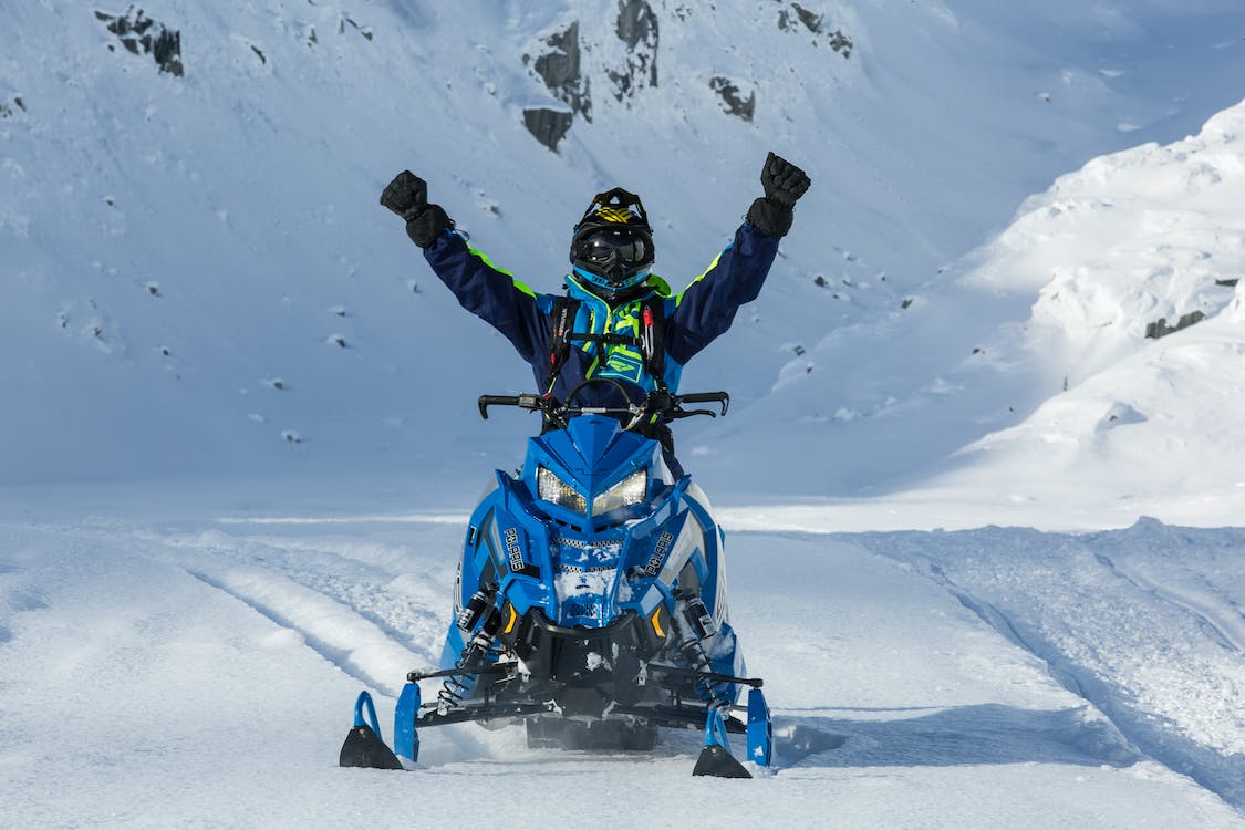 person riding a blue snowmobile