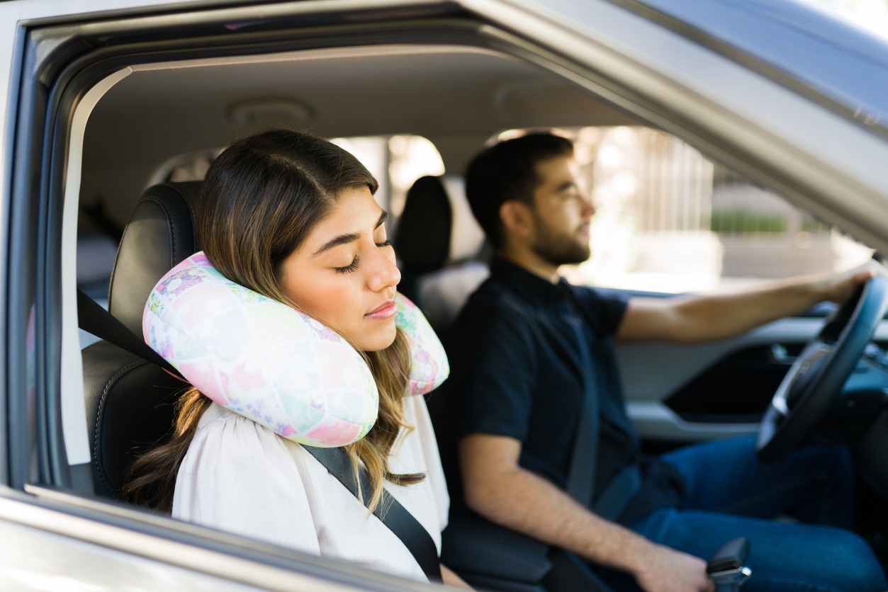 woman using a neck pillow in the car
