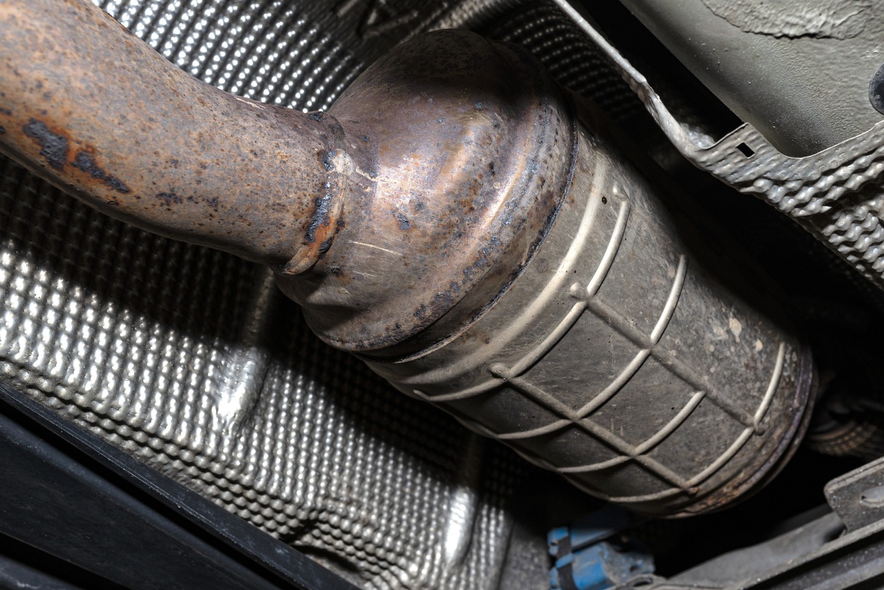 A diesel particulate filter in the exhaust system in a car on a lift in a car workshop. 