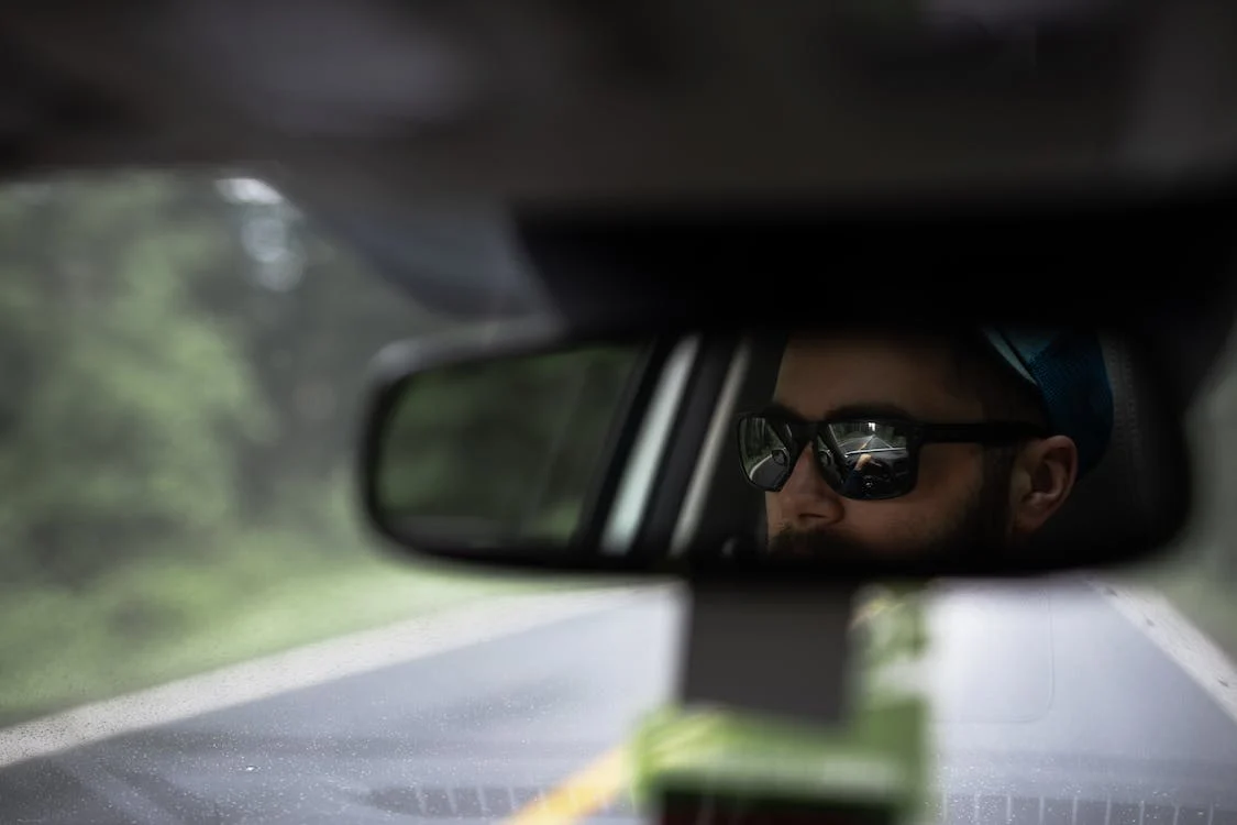 reflection of a man in rearview mirror