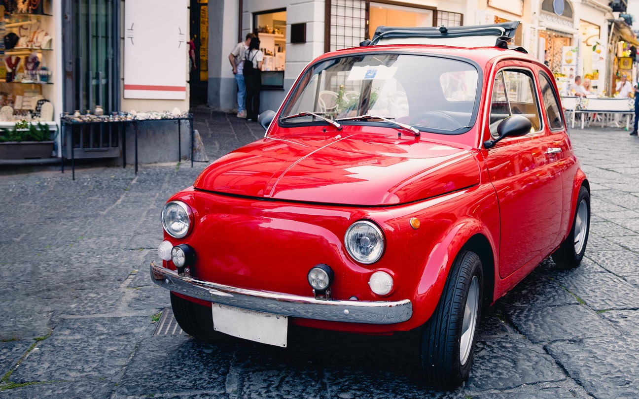a classic red car in an old European city