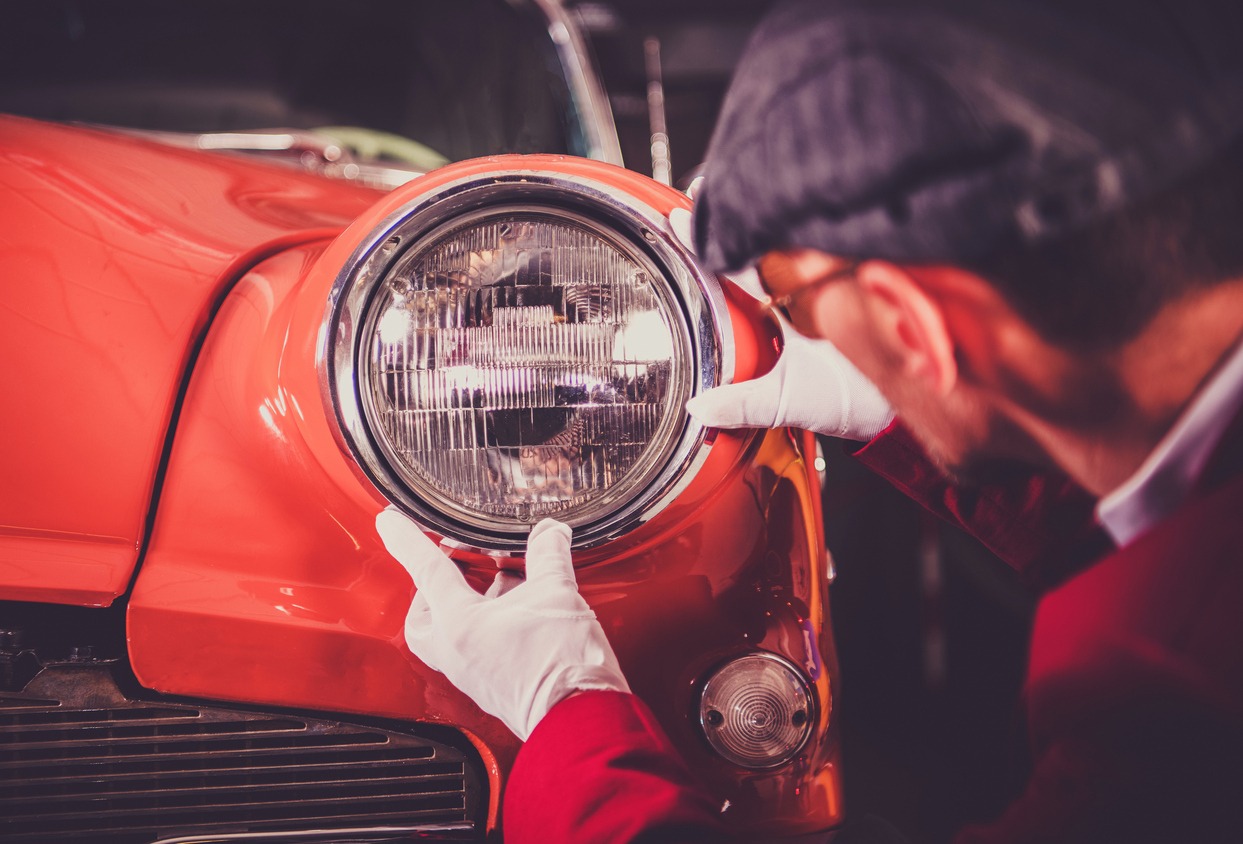 a man polishing a vintage car