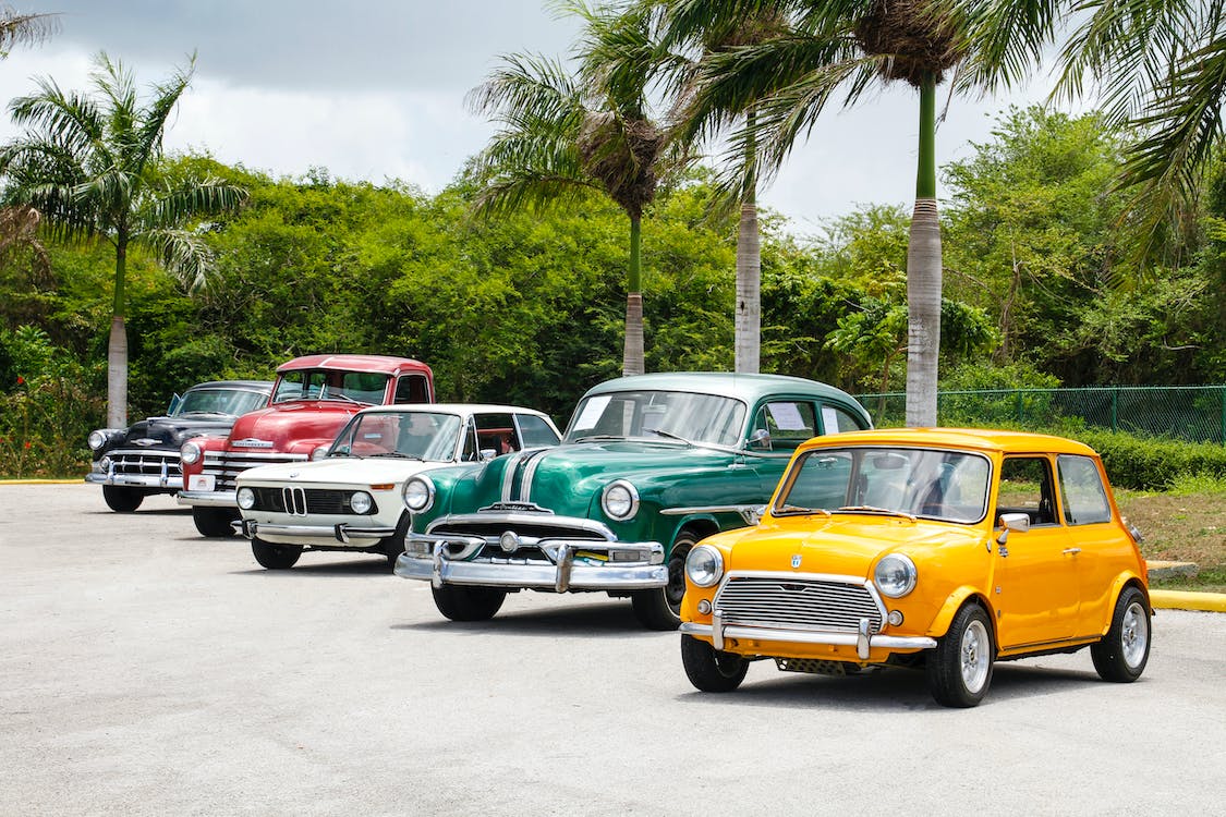 five classic cars parked