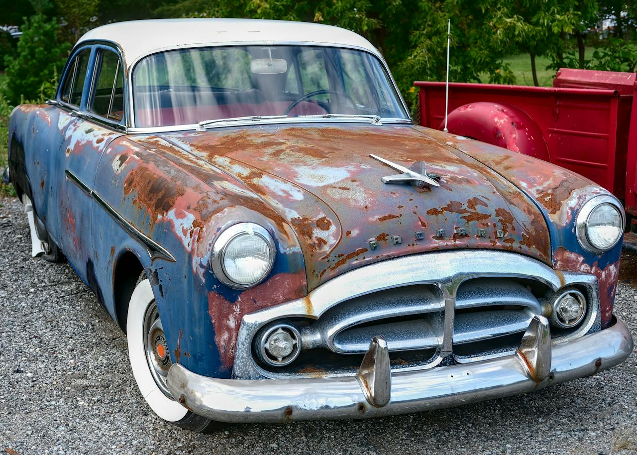 a rusting Packard in a parking lot