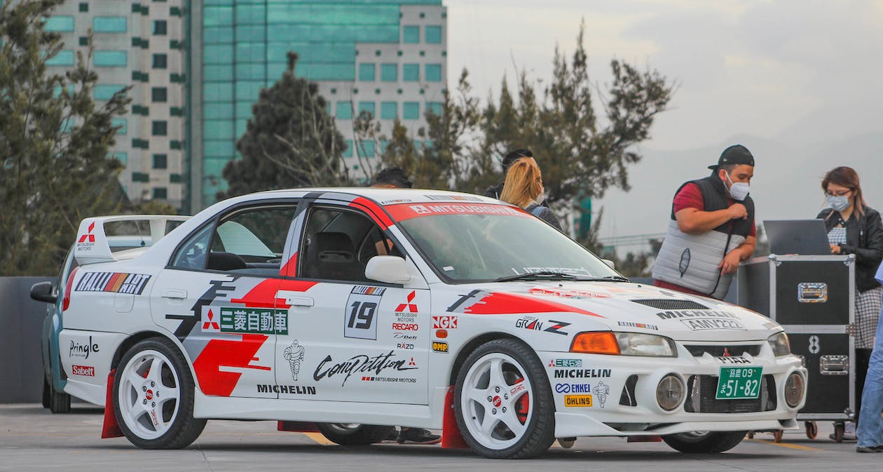 white and red modified Mitsubishi Evo for racing