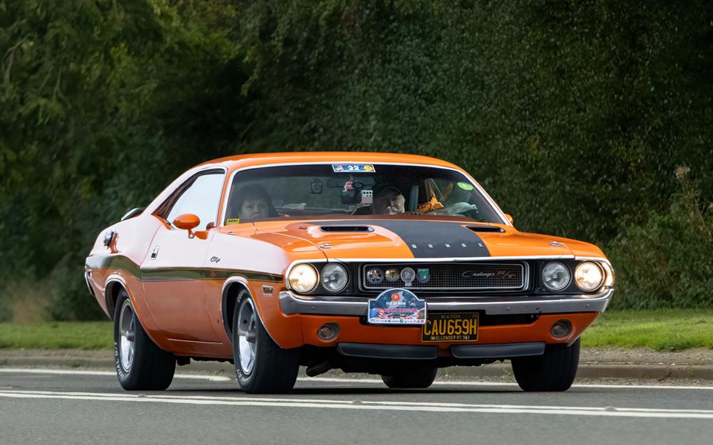 A Dodge Challenger driving on a British country road